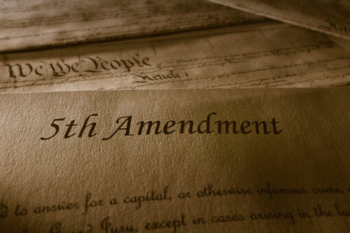 The 5th Amendment with US Constitution in the background