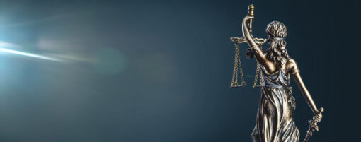 Statue of lady justice on dark background - rear view with copy space.